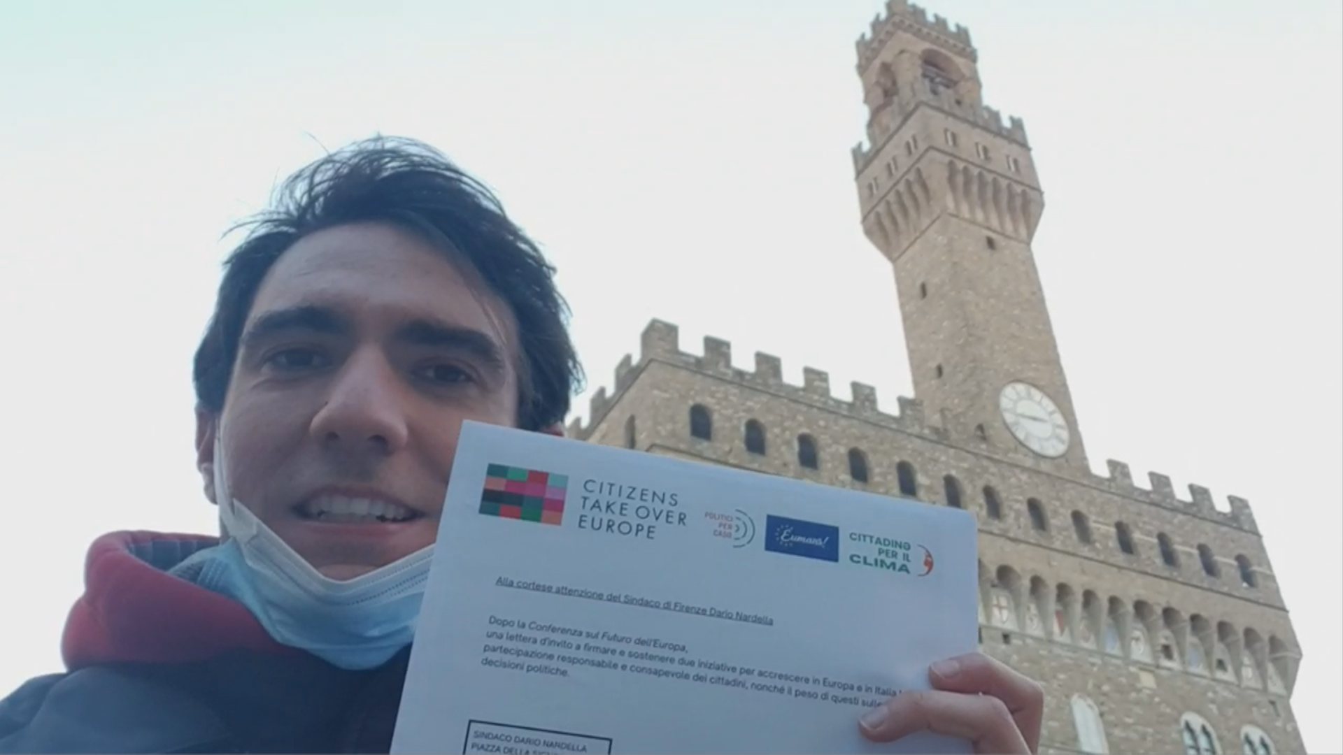 Samuele Nannoni con Eumans, Politici per caso e Citizens Take Over Europe a Firenze fuori Palazzo Vecchio mostra la lettera che sta per consegnare al sindaco di Firenze per chiedere sostegno al sindaco sulle iniziative per le assemblee dei cittadini.
